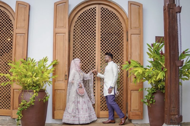 Couple at wooden lattice doorway with tropical plants