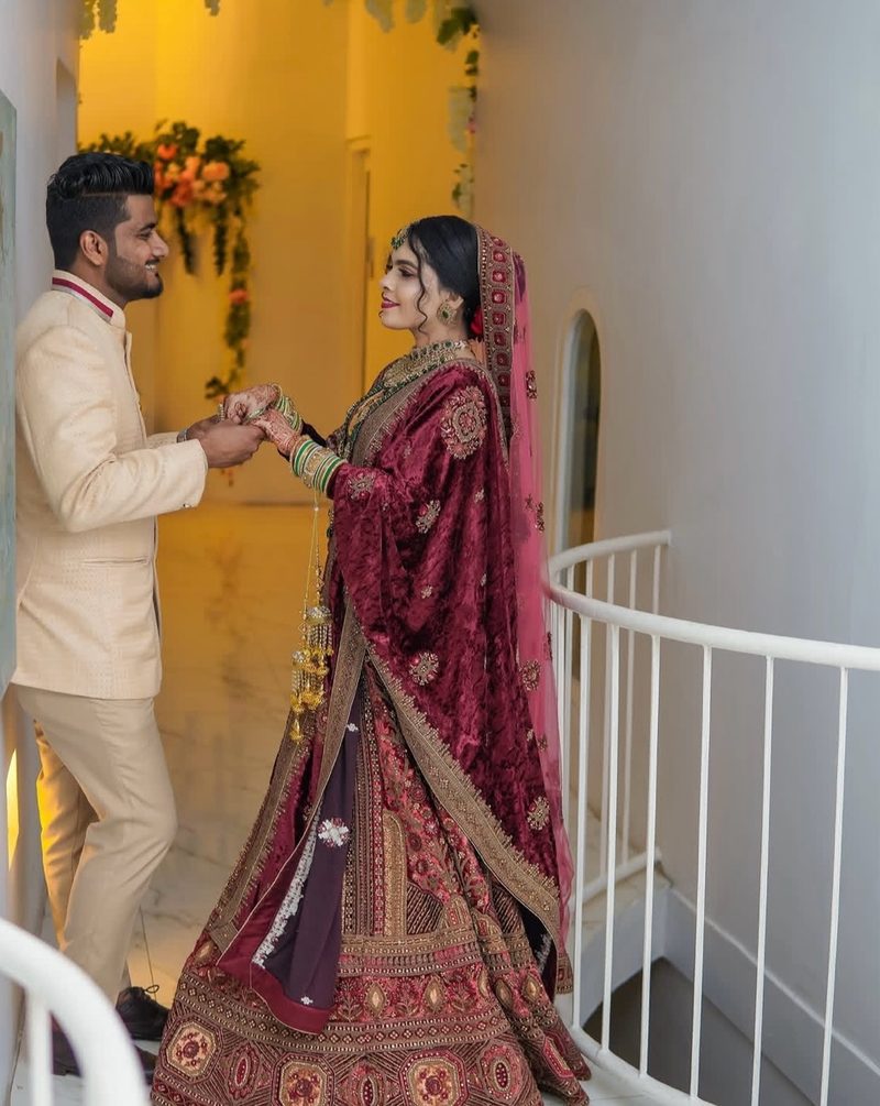 Couple in maroon and beige attire on a staircase