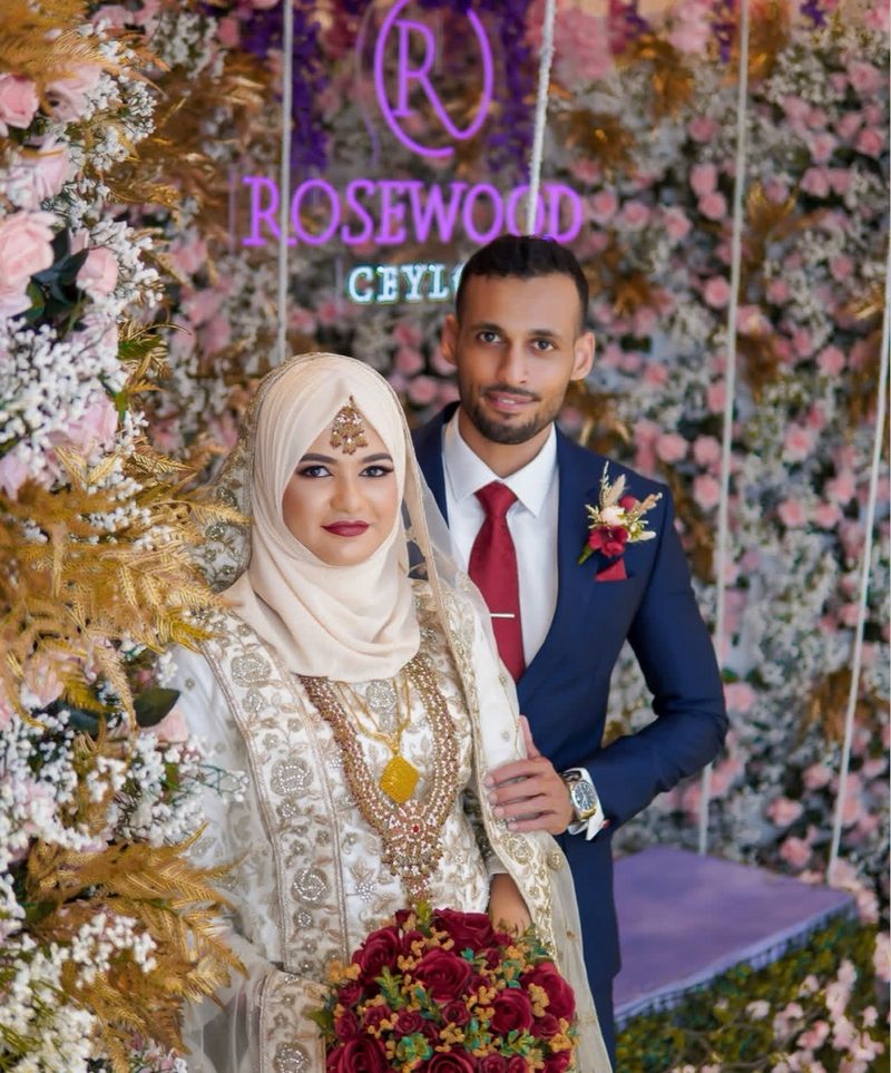 Couple at Rosewood reception with floral backdrop
